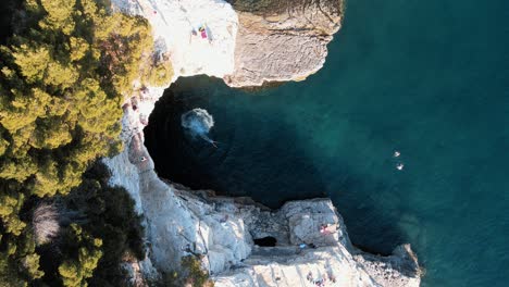 swimming by galebijana cave pula island - aerial drone shot