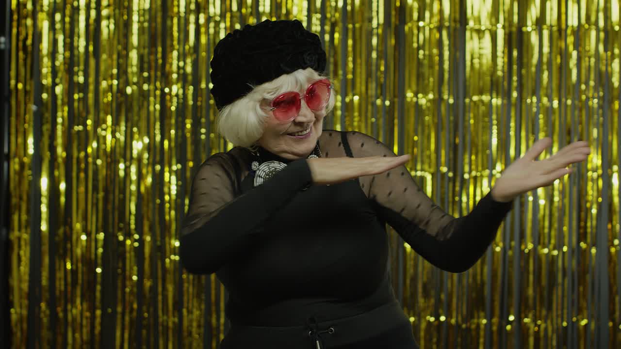 una anciana senior baila, celebra, escucha música, se mueve enérgicamente al ritmo, se relaja.