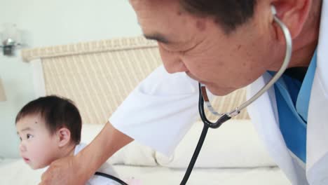 doctor examining baby on bed