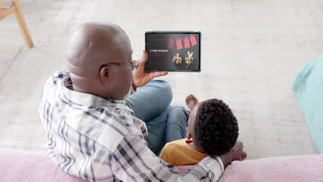 African-american-grandfather-and-grandson-using-tablet,-online-shopping-on-cyber-monday,-slow-motion