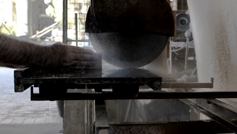 a worker cutting a brick with a circular saw