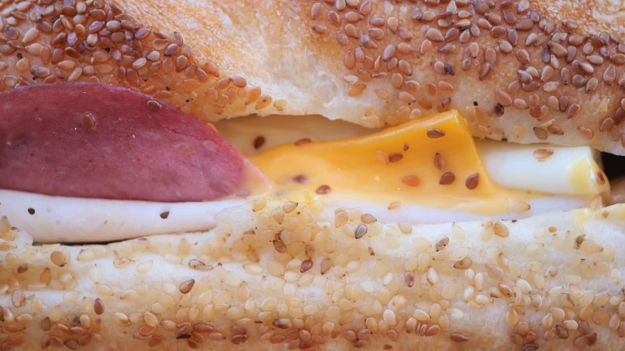 Close-up of a sesame seed sandwich with sausage and cheese