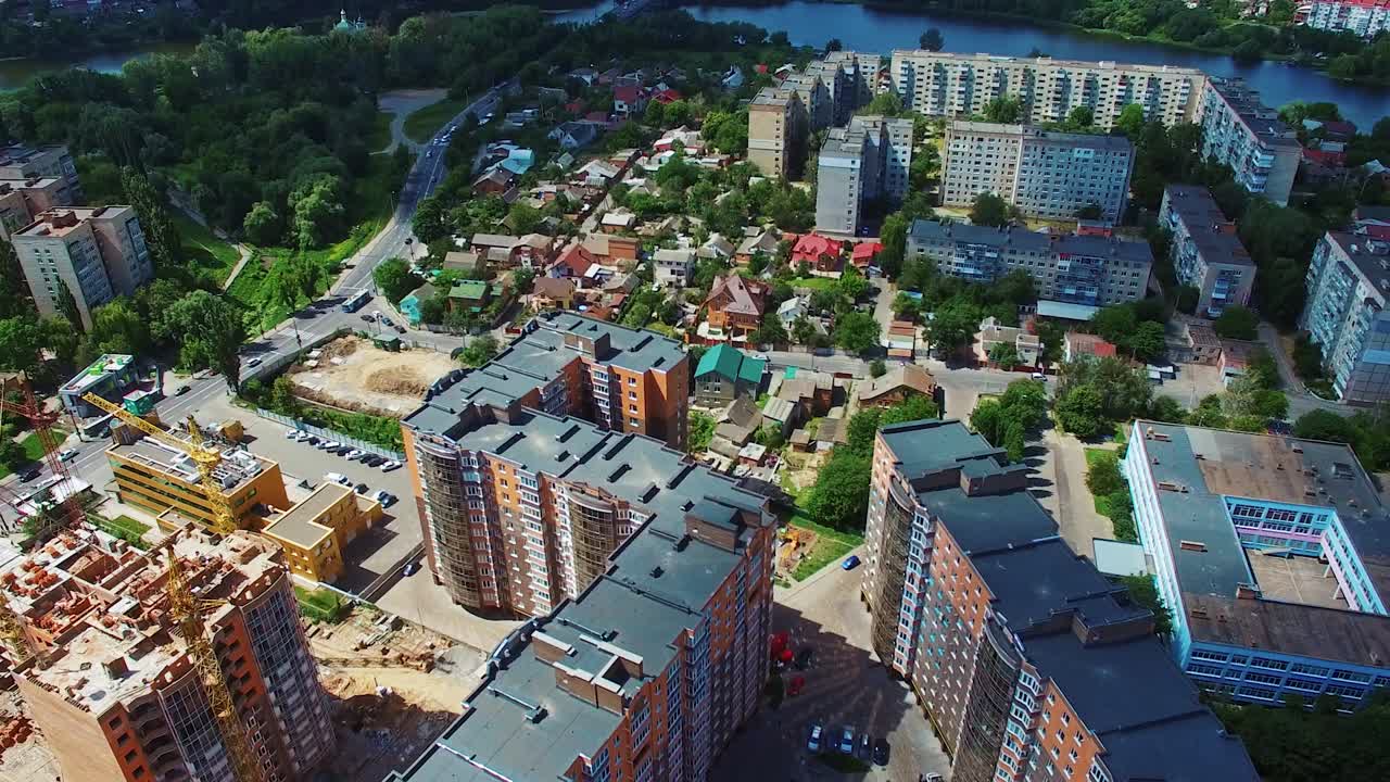 Modern industrial complex in the city. Development of high buildings. Construction site on the cityscape background. Aerial view.