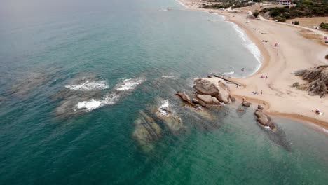Drohnenvideo,-Absteigende-Welle,-Krachende-Meeresfelsformationen-Offenbaren-Die-Küste-Des-Sandstrandes