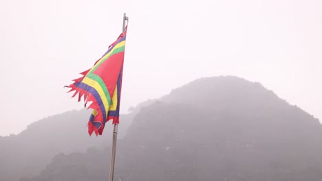 colorful historic flag flapping in the wind in in the mountainous region of ninh ninh in northern vietnam