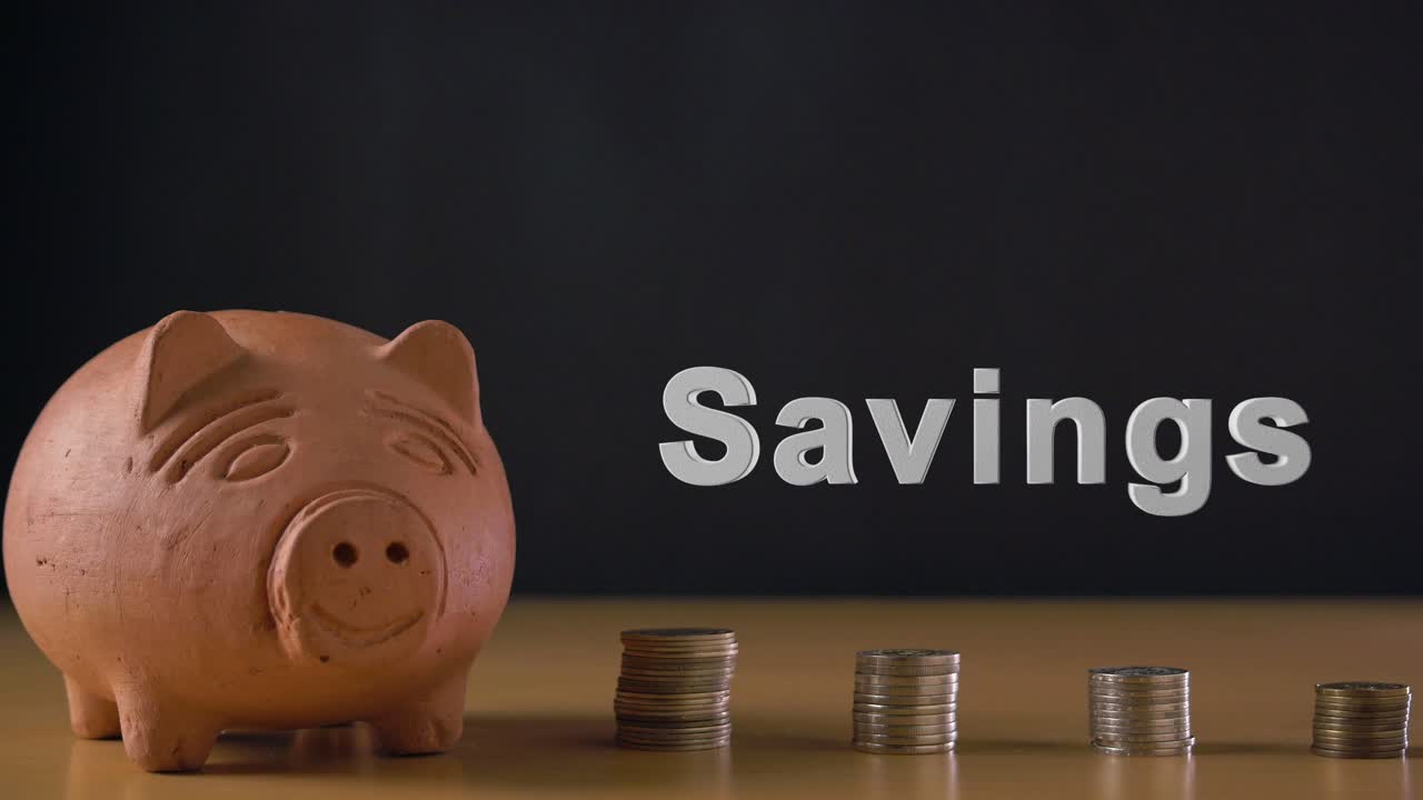 Savings text and hand of a white man putting a coin in a clay piggy bank