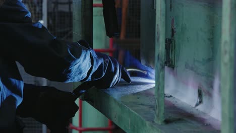 close-up of a worker welding machinery in an industrial workshop in slow motion