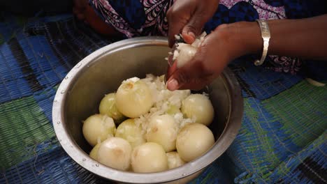 A-close-up-shot-of-a-black-woman-hands-cutting-an-onion-without-a-cutting-board