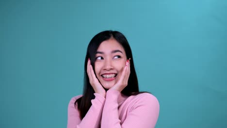 푸른 스크린 배경에 정형 치과 장치를 착용 한 미소 짓는 아시아 여성. 치과 관리와 건강한 치아.