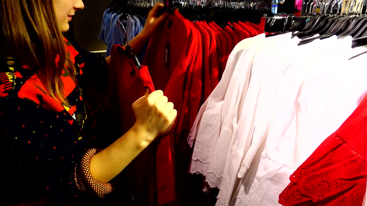 유럽의 쇼핑몰에서 소녀는 옷을 선택합니다.