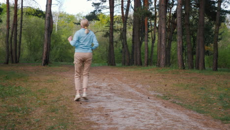 mujer caminando por un camino del bosque