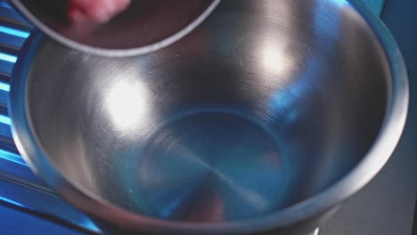 fresh uncooked ground turkey meat into stainless mixing bowl