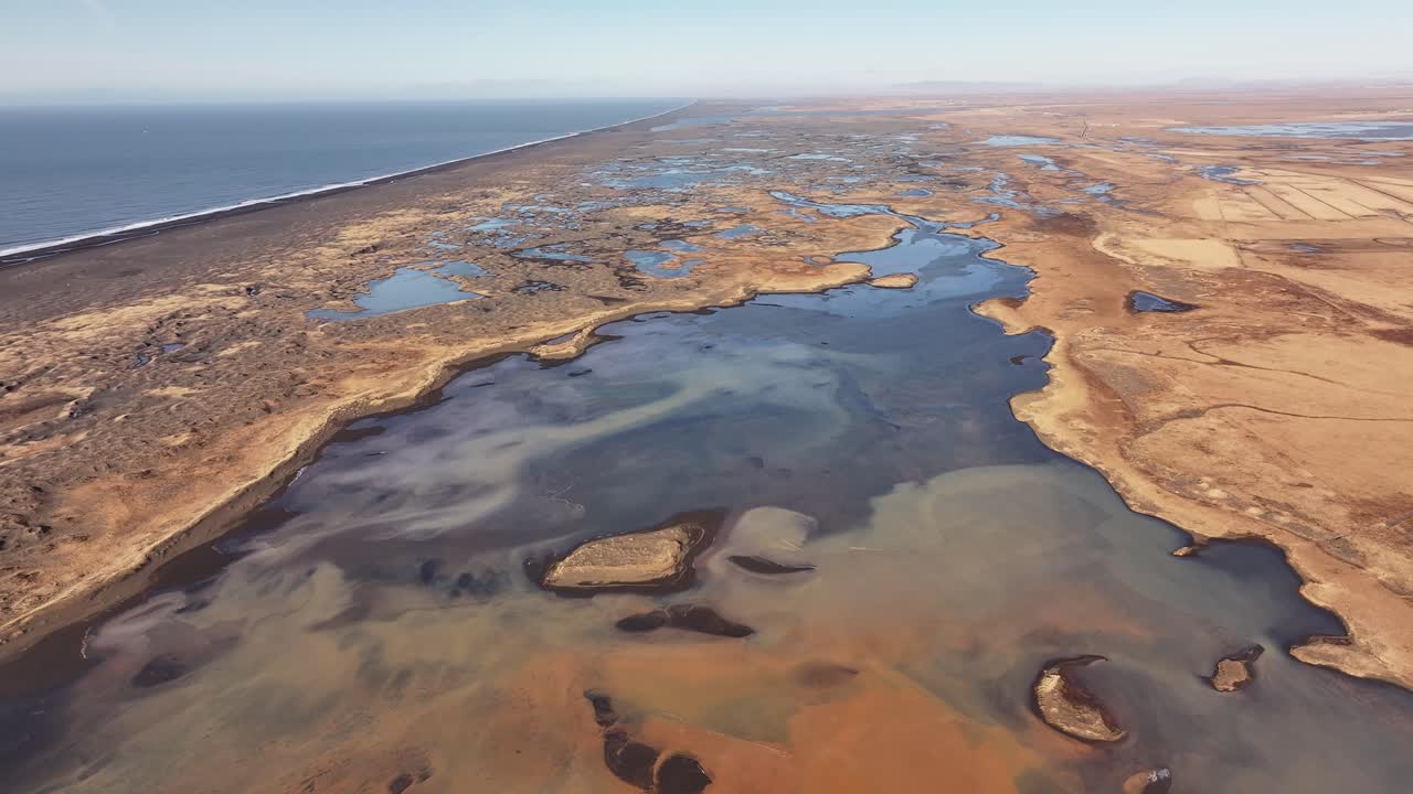 Aerial view of the glacial Þjórsá river, Yellow River, flowing towards the sea in Iceland. Stark, braided river delta landscape.