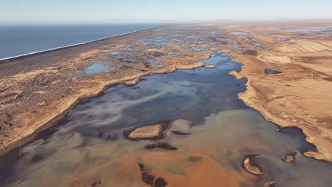 aerial view of the glacial þjórsá river, yellow river, flowing towards the sea in iceland. stark, braided river delta landscape.