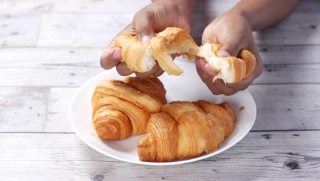 men eating croissant bun top view