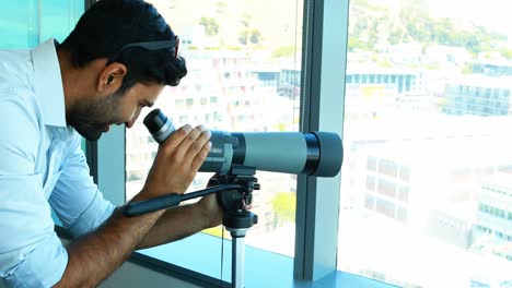 Male-executive-looking-through-telescope