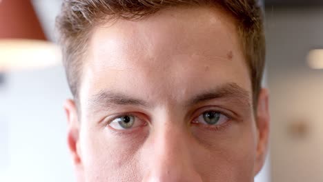 Portrait-of-happy-short-haired-caucasian-businessman-opening-blue-eyes-in-office,-in-slow-motion