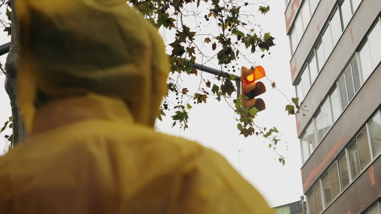 Business man tourist person with umbrella and raincoat on rainy european city street, lights reflecting, walking in Barcelona or Amsterdam during the rain