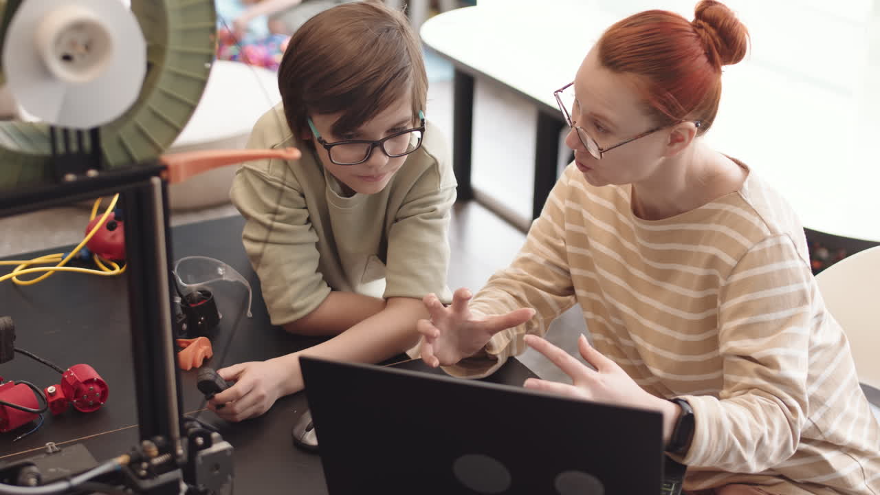 Female Teacher and Intelligent Schoolboy Using Laptop during Lesson