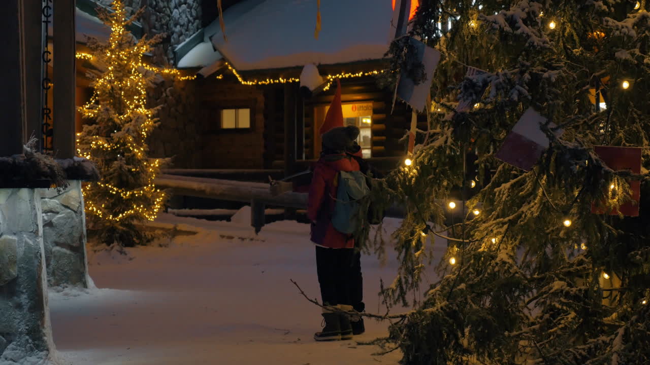 십대 들 이 크리스마스 를 위해 장식 된 공원 에서 모바일 셀피 를 찍고 있다