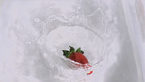 strawberry falling into water in super slow motion