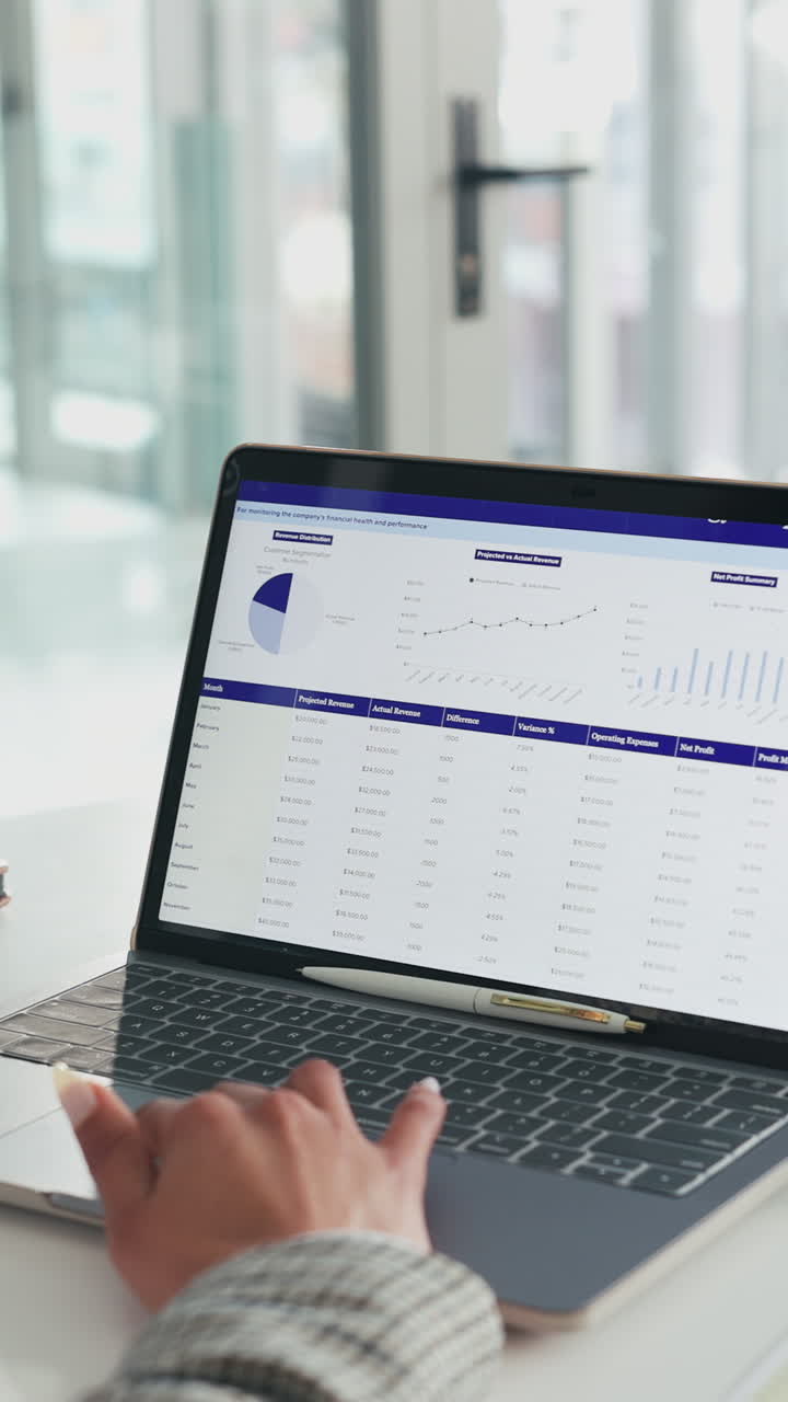 Close-up of Hand Typing on Laptop Displaying Business Financial Data