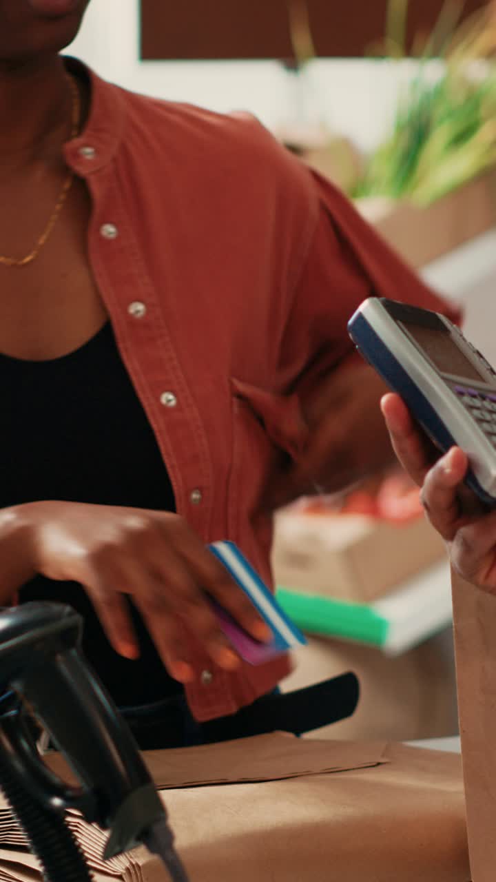 Vertical Video Woman paying for bulk products with card at pos
