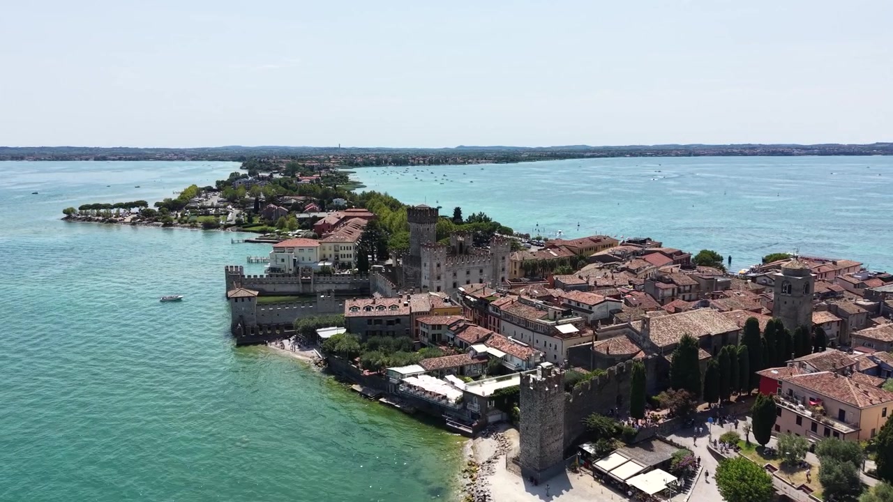 Vista drone del Castello Scaligero, del centro storico di Sirmione e della penisola circondata dalle acque limpide del Lago di Garda, Italia