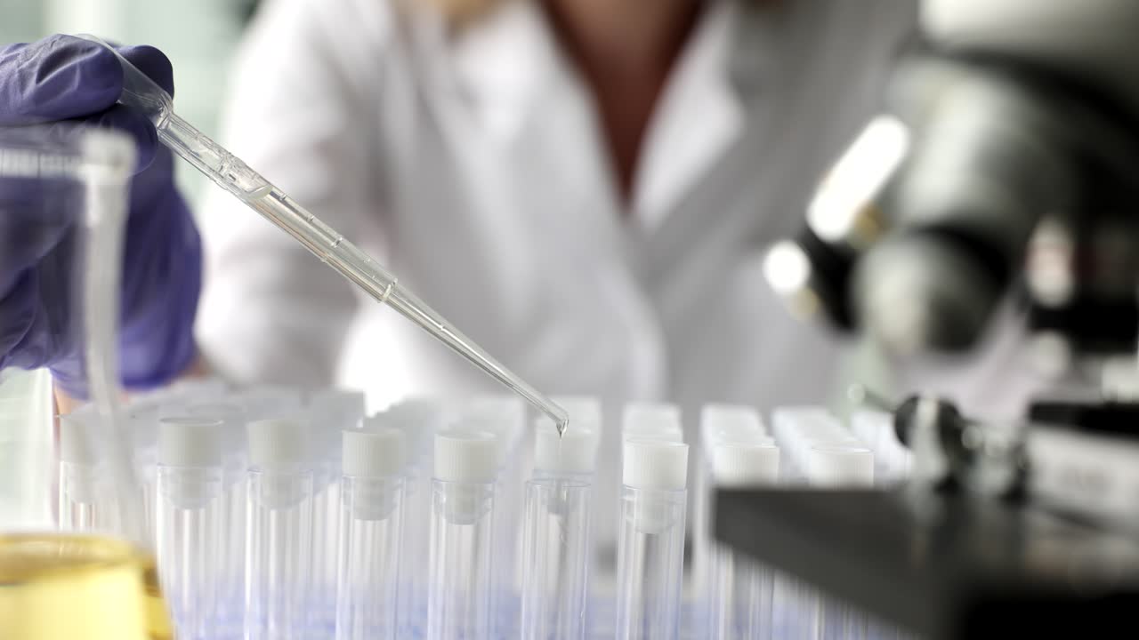 Scientist dropping liquid into test tubes in a laboratory