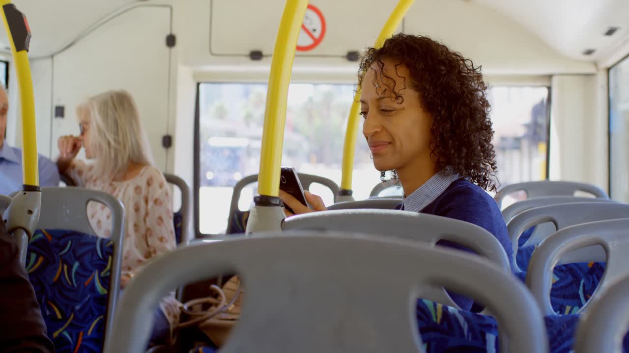 Commuters using and talking on mobile phone while travelling in bus 4k