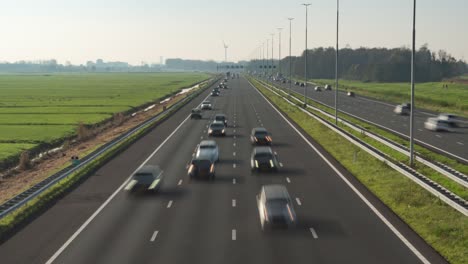 Busy-commuter-traffic-passing-under-highway-bridge,-time-lapse-zoom-in