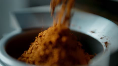 spices being poured into a grinder