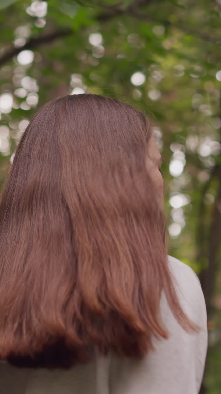 숲에서 조하는 젊은 여성 운동선수. 은 머리 여성은 나무로 둘러싸인 전문적인 피트니스 훈련의 일환으로 심장 중심의 조에 참여합니다.