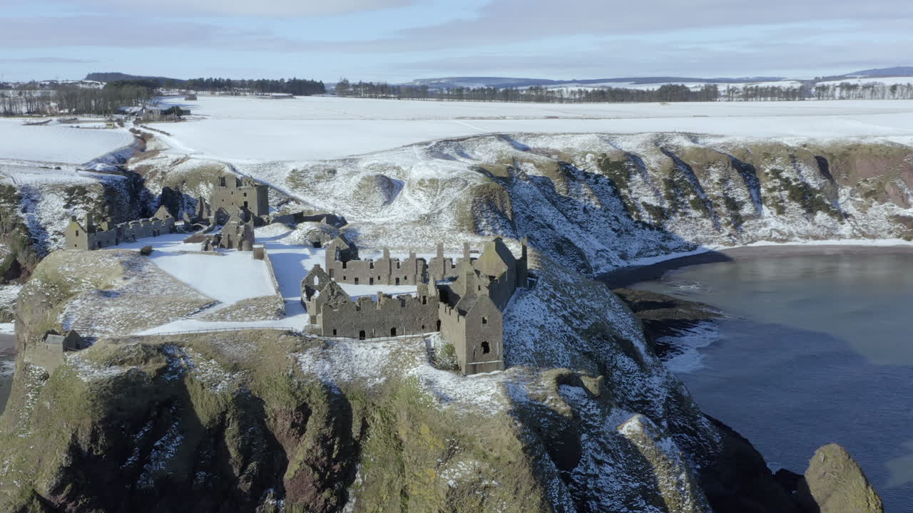 화창한 겨울날 눈으로 둘러싸인 던노타 성터의 공중 전망, nr 스톤헤이븐, 애버딘셔, 스코틀랜드