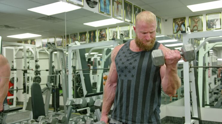 Active bodybuilder young man lifting heavy weights