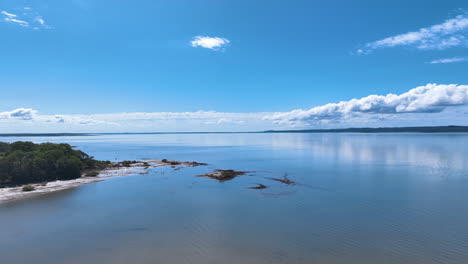 Aerial-flies-out-of-Queensland's-Cooloola-Cove-over-vast-reflective-waters