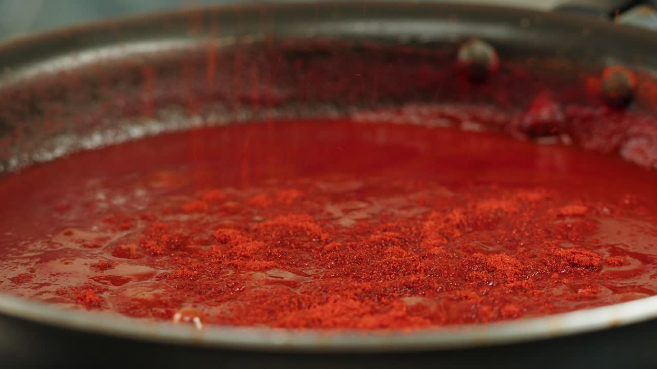 Boiling tomato sauce on a frying pan close-up. Cooking tomato sauce or soup. Traditional Italian Mexican Asian dish. High quality studio shot for cafe, restaurant close up. Marinara sauce for Italian pasta