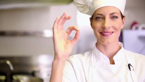 Pretty-chef-smiling-at-camera-and-giving-thumbs-up