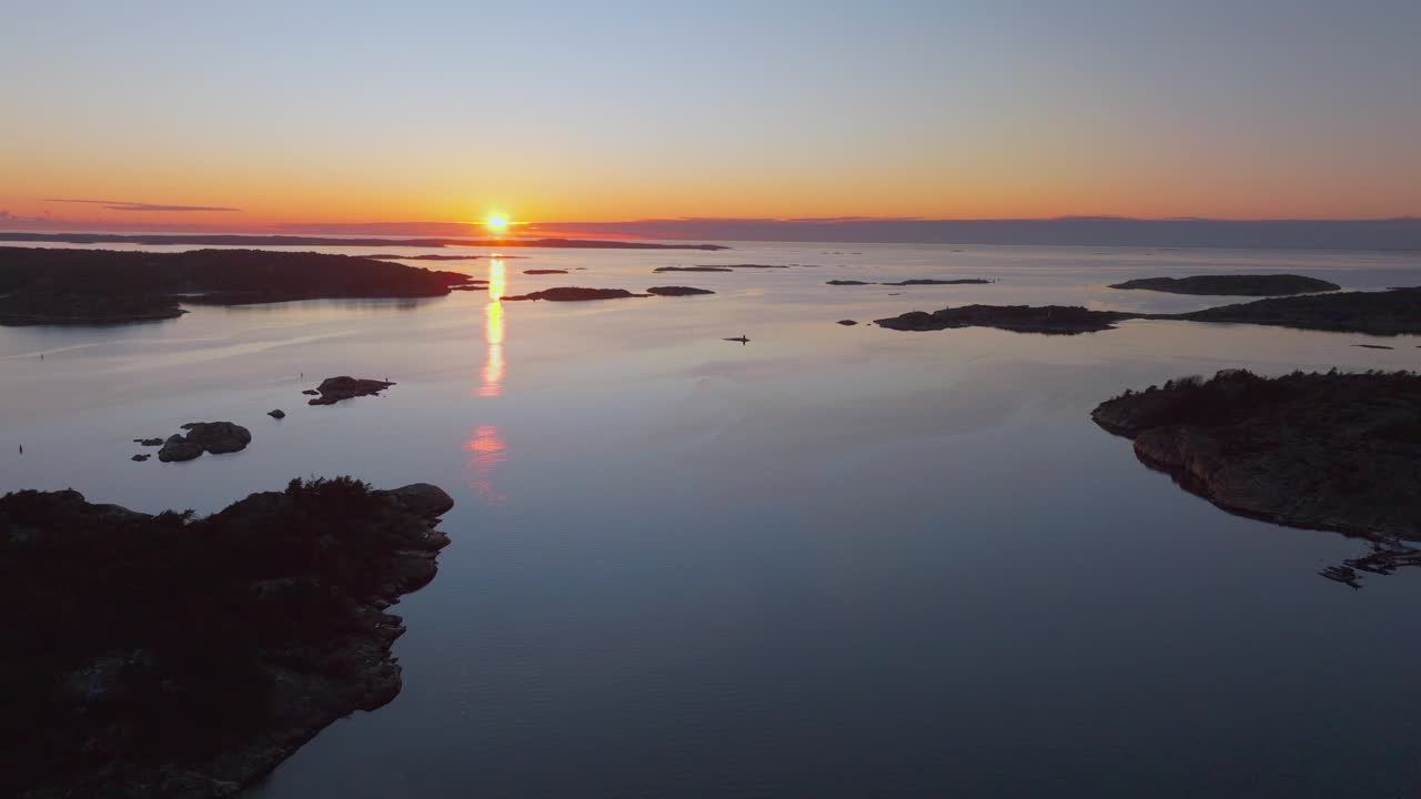 Strömstad Stromstad Sweden aerial drone Arctic Circle islands golden sunset sun on horizon peaceful calm still Sandelfjord Fjord Baltic Sea marina harbor picturesque seaside pan right