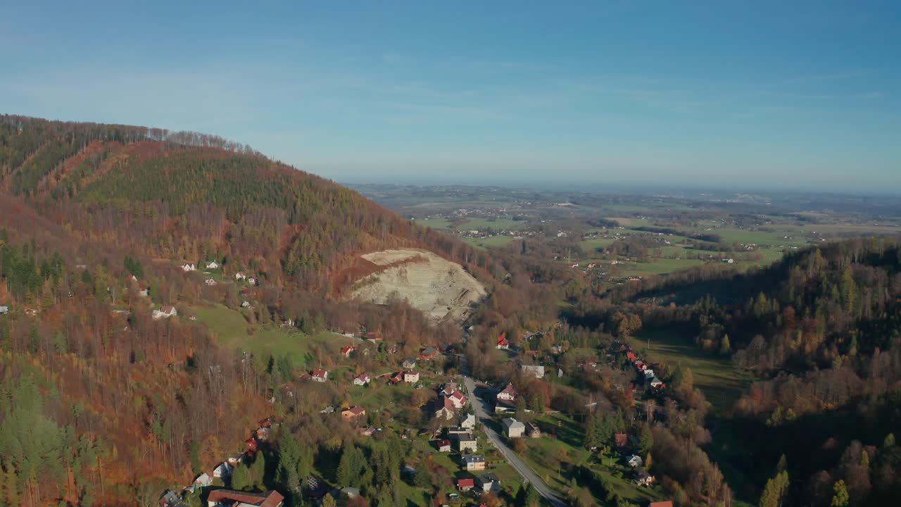 toma aérea de un avión no tripulado de una aldea y una cantera en medio de las montañas de beskydy durante un soleado día de otoño
