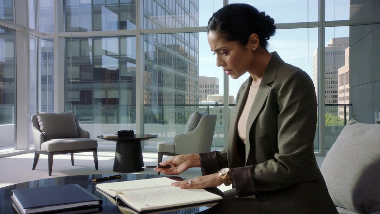 Opening pad, woman in blazer flipping pages in lounge, tapping phone, reviewing notes, copy space