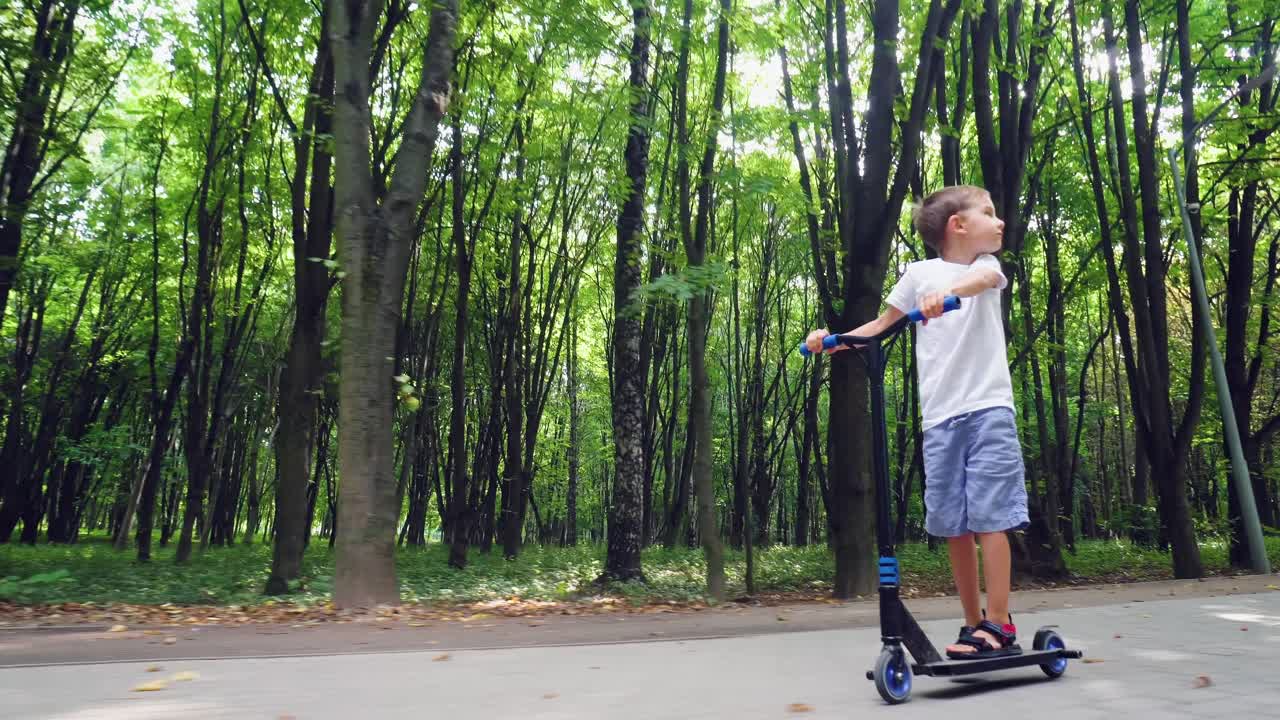 A boy rides a scooter in a city park 07