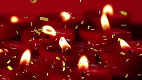 Animation-of-gold-confetti-falling-over-lit-red-candles