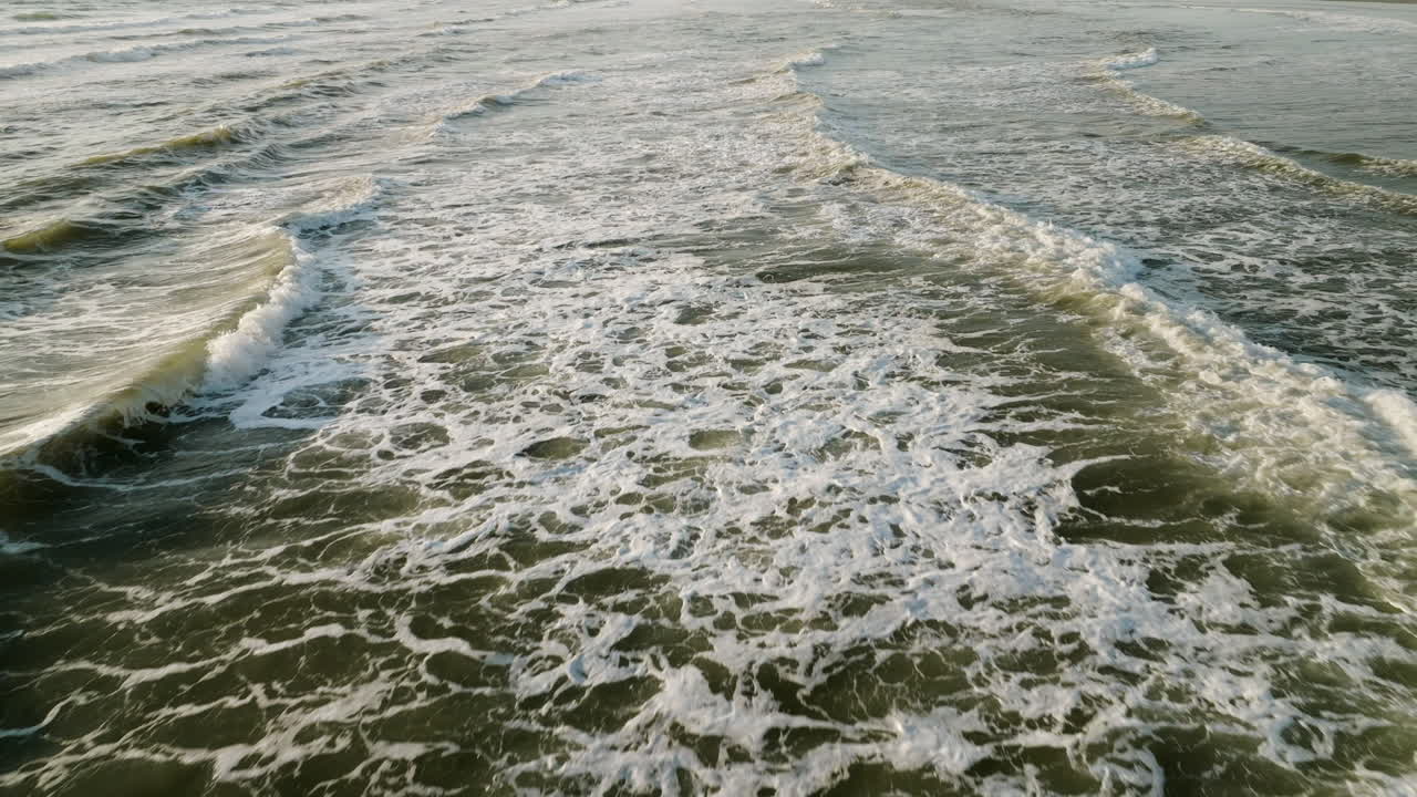 Powerful ocean waves crash and whitewash tendrils churn around, natural water backdrop in slow motion