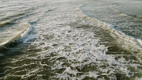 powerful ocean waves crash and whitewash tendrils churn around, natural water backdrop in slow motion