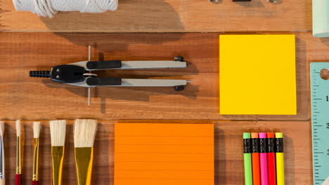 animation of compass, brushes, memo notes and pencils on organised school desk