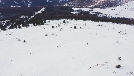 aerial tilt up of skier skiing alone on the empty snow covered piste during covid-19 pandemic