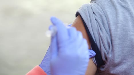 close-up video of a man's arm being injected with the corona virus vaccine