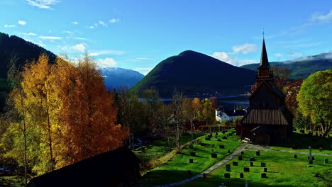 Aerial-view-around-a-Stavkyrkje-church-in-middle-of-autumn-colors-of-Norway