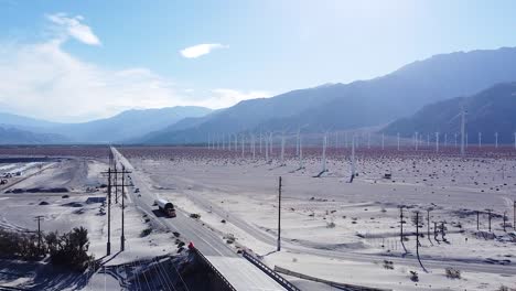 concurrida carretera americana del desierto y enorme granja de molinos de viento, vista aérea de drones